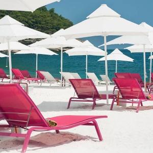 Vibrant Fuchsia Sun Loungers contrast against crisp white at this mediterranean resort.
