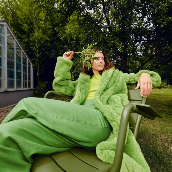 Woman reclining on green outdoor chair