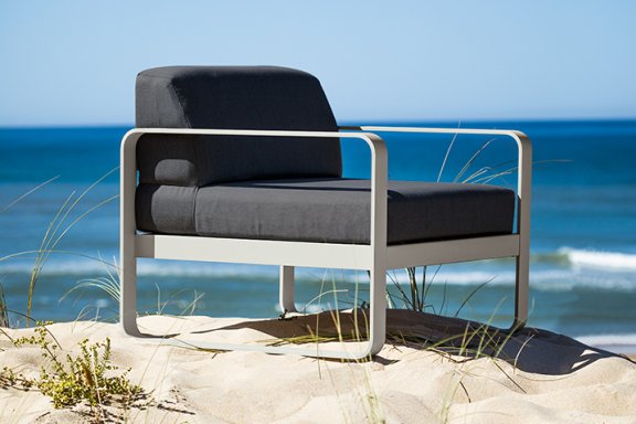 Fermob Bellevie sofa armchair sitting on a sand dune at beach