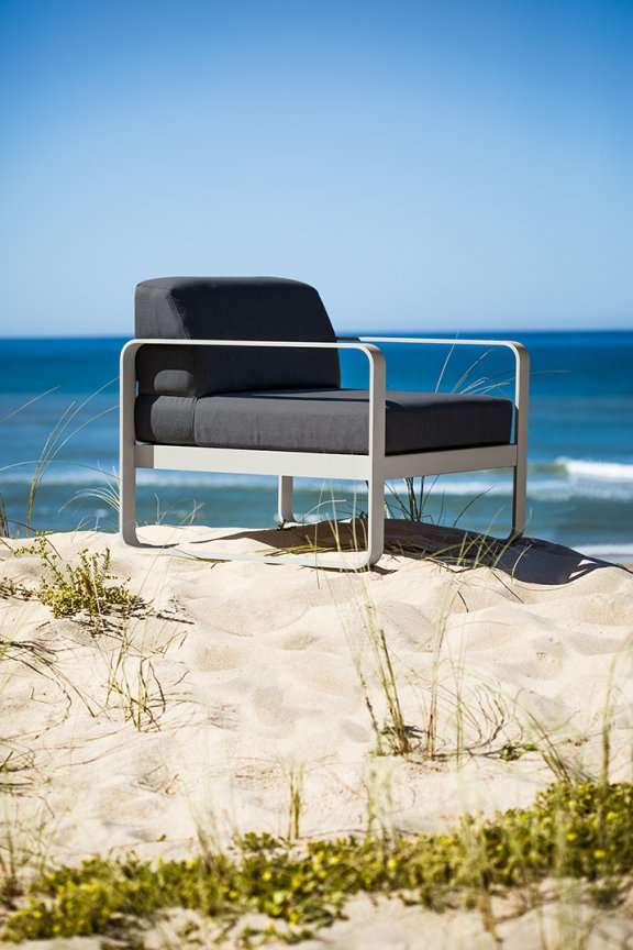 Fermob Bellevie sofa armchair sitting on a sand dune at beach