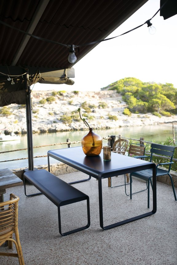 Liquorice black Fermob Bellevie rectangular dining table with bench seat and an assortment of outdoor chairs