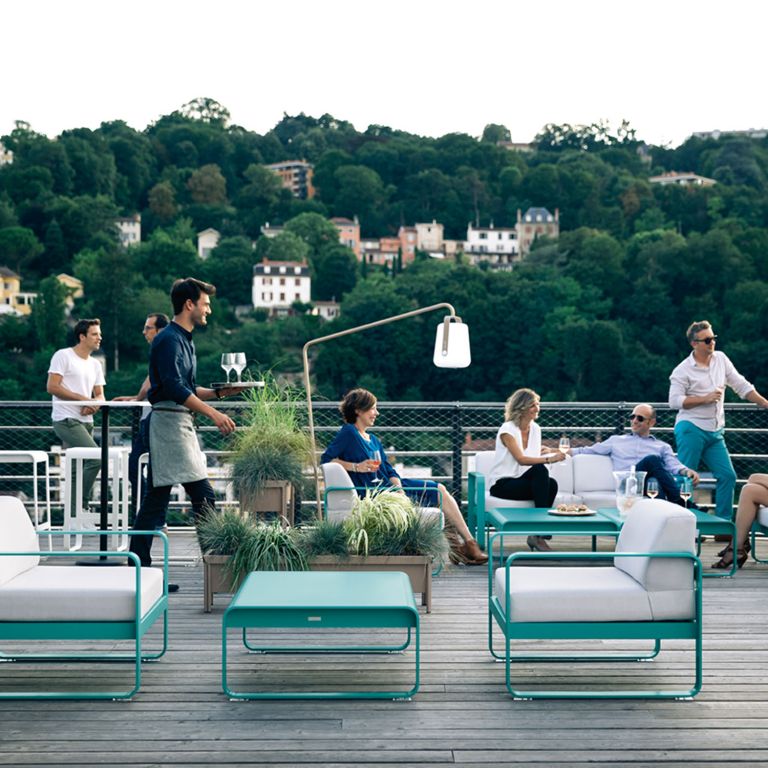 Fermob Bellevie outdoor sofas and coffee tables in a commercial setting at Rooftop 52 bar in Lyon