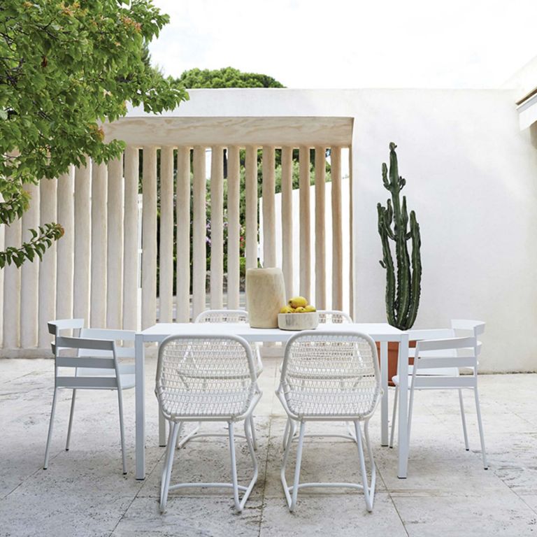 Fermob Sixties outdoor dining chair with a Rythmic chairs around an InsodeOut table in a terrace