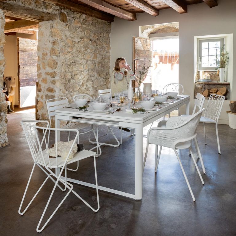 Fermob Biarritz extendable outdoor table in Cotton White surrounded by assorted Fermob chairs